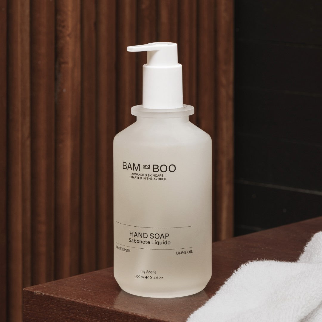 BAM AND BOO hand soap bottle on a wooden surface with a blurred background. Luxury natural skincare amenities for daily rituals.